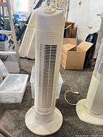 Full view of white Facto tower fan on base showing vented front grille and power cord