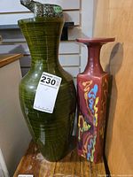 Green ribbed vase and maroon square drip-glaze vase side by side