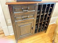 Front view of cabinet showing drawers, door and wine rack