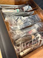 Bagged and banded stainless steel flatware pieces in drawer
