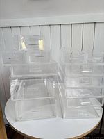 Both stacks of acrylic drawers on round table showing full quantity and size variation