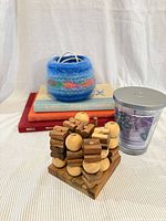 Overall lot view showing wood tic tac toe, felted bowl, candle, books