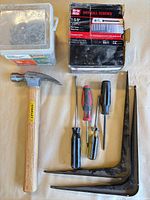 Group shot of all items: hammer, screwdrivers, brackets, screw box, nail bin