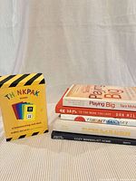 All six items: Thinkpak box and five stacked paperbacks