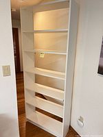 Full view of white Billy bookcase standing against wall