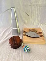 group shot of all five items: fly fan, cutting board with ulu knife, trinket box, ceramic bottle stopper