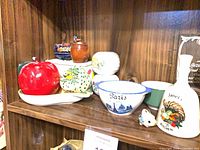 Shelf with apple container, Paris bowl, decorative bell, assorted jars