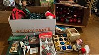 overview of lot showing ornaments, boxed lights, packaged ornaments and tree stand pieces