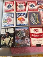 Nine playing card decks including Bicycle, Elvis, Maine and Aristocrat visible in plastic tray