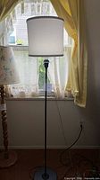 Full view of lamp showing stand, base, shade, cord
