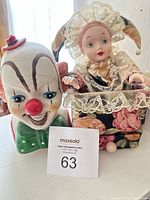 Both items side by side: ceramic clown cookie jar and porcelain jack-in-the-box doll