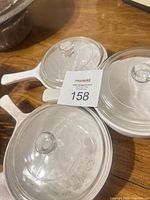 Top view of three dishes with lids showing handles and glass tops
