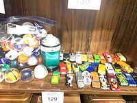 Shelf view showing bag of helmet ornaments, green pouch and full row of die-cast cars