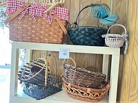 Overview of top shelf baskets including picnic basket, teal basket with butterfly, small grey basket