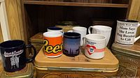 Group shot of eight assorted mugs on shelf