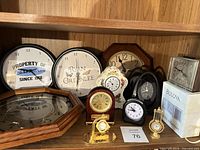 Full shelf view showing nine assorted clocks and Bulova box