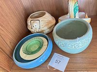 Shelf view showing four ceramic planters/bowls and nested dishes