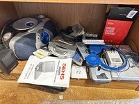 Overview of shelf with boombox, portable CD players, manual, speakers, headphones, accessories