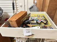 Drawer view showing wood knife block, utensil tray with flatware and assorted miscellany
