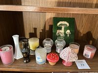Shelf with mixed candles, vases, mushroom figurines and plaque