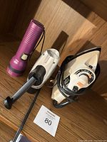 All three items on shelf: iron, curling iron, flashlight