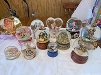 Group shot of all thirteen snow globes arranged on table
