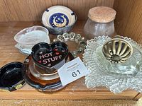 Group view showing heart ashtray, amber dish, black ashtray, stacking dishes, ceramic bowl, glass ring, jar, pressed glass with brass insert