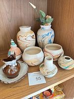 All nine pottery pieces on shelf showing overall condition and colour