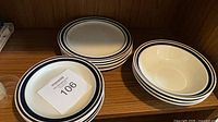 Stacked dinner plates and bowls on shelf showing rim pattern