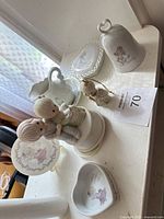 Full lot overview showing all seven Precious Moments porcelain items