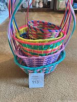 Stacked view of five nested multicolor plastic Easter baskets showing sizes and colors