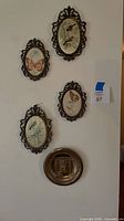 Wall view showing four oval prints and round plate for size and style reference