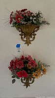 Both wall pocket sconces mounted on wall with artificial flower arrangements