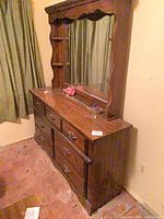 Front angled view of dresser showing drawers and attached mirror