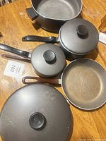 Top view showing all pots, pans and lids arranged on table