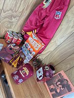 Full lot showing jacket, drinkware, Wheaties box, blankets, cans, cap, and smaller items