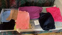 Overview of folded clothing pieces on plastic drawer