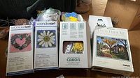 Four boxed latch hook kits with loose yarn and canvas pieces