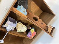 Group view of owl shelf, planter cart, heart plaque, birdhouses on display unit