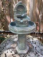 Assembled view of cast stone tiered fountain showing pedestal, basin, riser, and spout