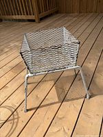 White mesh metal plant stand on deck showing overall form