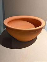 front angled view of unglazed terracotta planter showing bowl shape and smooth rim