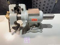 Side view of grey cast iron 5-inch bench vise on white surface
