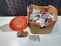 Box with ribbons, plaque, bird ornament, metal dish