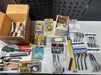 Overview of lot showing brushes, blades, tape and fasteners laid out on table