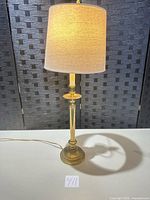 Full view of brass table lamp with shade lit