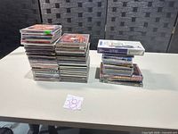 Two stacks of assorted CDs, DVDs and one VHS visible