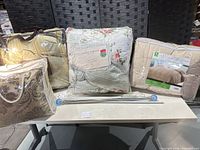 Group shot of all packaged comforter sets, decorative pillow set and chrome curtain rods