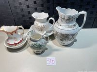 Group view: four pitchers on table with one wash basin visible