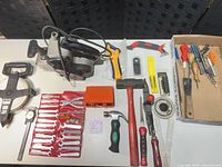 Overall lot on table including belt sander, wrenches, measuring tape and hand tools